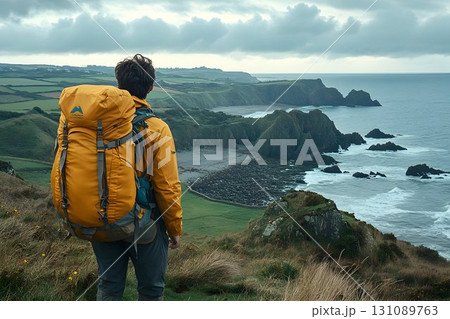 Coastal Hike: Backpacker Gazing at Dramatic Cliffs and Ocean Coastal Hike: Backpacker Gazing at Dramatic Cliffs and Ocean 131089763