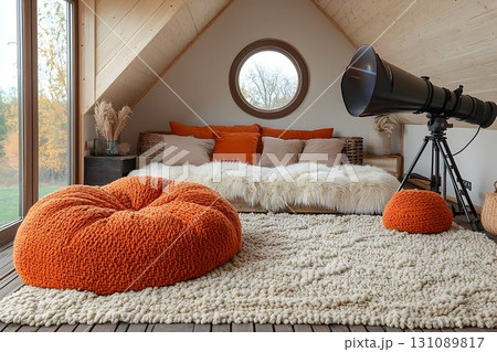 Cozy attic bedroom with telescope, orange beanbags, and round wi 131089817
