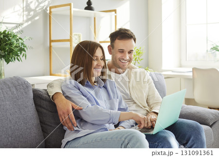 Happy Couple Relaxing And Enjoying Online Entertainment On A Sofa At Home Happy Couple Relaxing And Enjoying Online Entertainment On A Sofa At Home 131091361