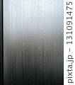 Detailed Close-up of Raindrops Sliding Down a Misty Glass Surface 131091475