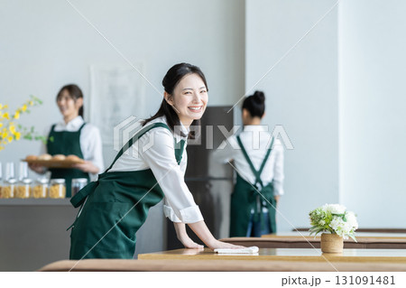 カフェで開店準備をする若い女性の店員 131091481