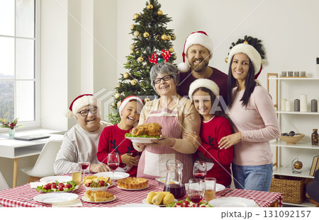 Portrait of happy family with roast turkey at festive Christmas lunch meal at home Portrait of happy family with roast turkey at festive Christmas lunch meal at home 131092157