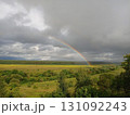 Rainbow in summer over the river, forest and fields, clouds with blue gaps in the sky, beauty 131092243