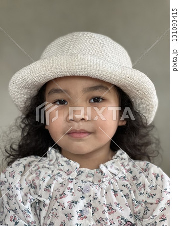 Portrait of Asian little girl with white hat on gray background. Portrait of Asian little girl with white hat on gray background. 131093415