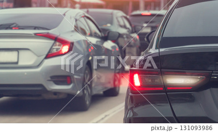 Rear side of black car with effect from brake light. Traffic jam in the city. Many cars are parked in a row on the asphalt road. Rear side of black car with effect from brake light. Traffic jam in the city. Many cars are parked in a row on the asphalt road. 131093986