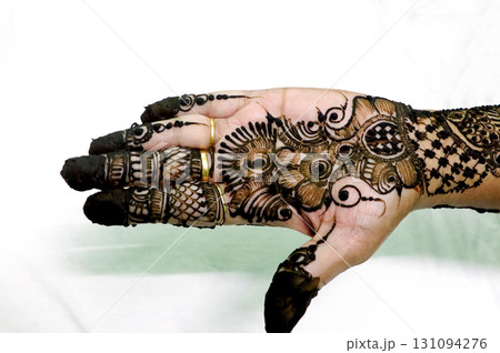 Picture of human hand being decorated with henna tattoo,Decorated Mehendi cone in Indian wedding ceremony Picture of human hand being decorated with henna tattoo,Decorated Mehendi cone in Indian wedding ceremony 131094276