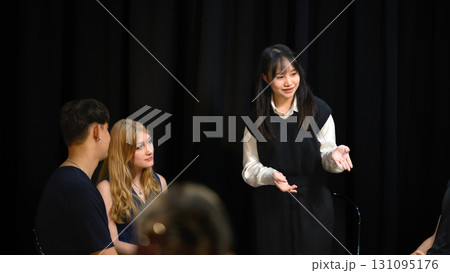 Young woman standing and speaking during a psychotherapy group session 131095176