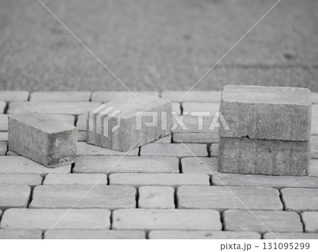 Row of bricks are laying on a gray sidewalk Row of bricks are laying on a gray sidewalk 131095299