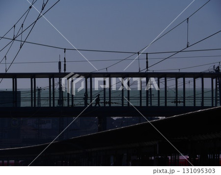 Bridge with wires above it and a person walking on it 131095303