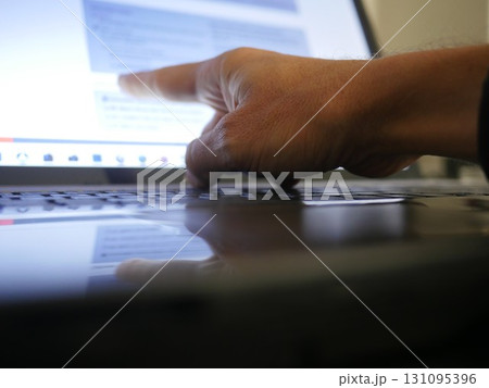 Hand is pointing at a laptop screen Hand is pointing at a laptop screen 131095396