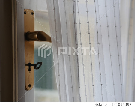 Gold handle on a door with a keyhole Gold handle on a door with a keyhole 131095397