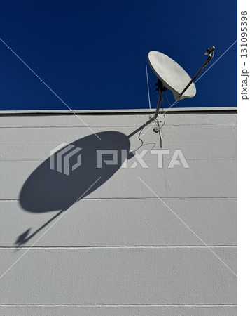A Satellite Dish Projecting a Shadow Beautifully on a Wall 131095398