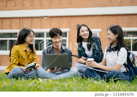 Asian Students are studying the campus park. Young people are spending time together. Reading book, working with laptop and tablet sitting on stairs 131095470