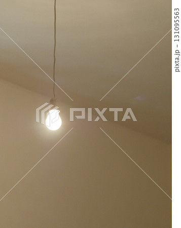 Single light bulb hanging from the ceiling 131095563