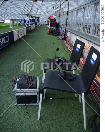 Two chairs with microphones on them sit on a grassy field 131095569