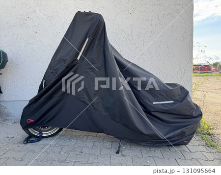 A Motorcycle That is Completely Covered with a Protective Black Covering Material 131095664