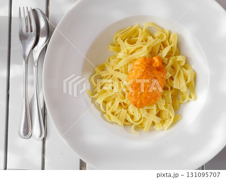 Plate of pasta with a sauce on top Plate of pasta with a sauce on top 131095707