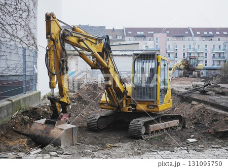 Yellow construction machine is digging in the dirt Yellow construction machine is digging in the dirt 131095750