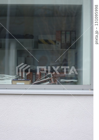 A window with a desk and a pile of papers A window with a desk and a pile of papers 131095998