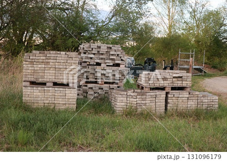 Pile of bricks and wood are stacked in a field Pile of bricks and wood are stacked in a field 131096179