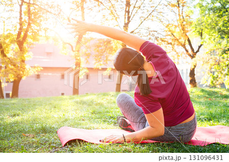 Woman runner stretching, sports shoes and athlete touching toes on a yoga mat on floor for leg fitness warm up exercise. Female athlete, training for flexibility and healthy cardio running workout 131096431