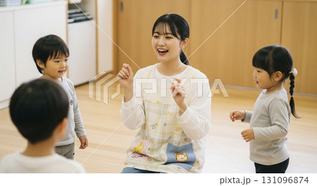 保育士と園児たちが屋内でお歌遊びをするシーン 131096874