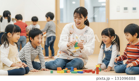 保育士と園児たちが屋内でブロック遊びをするシーン 131096888