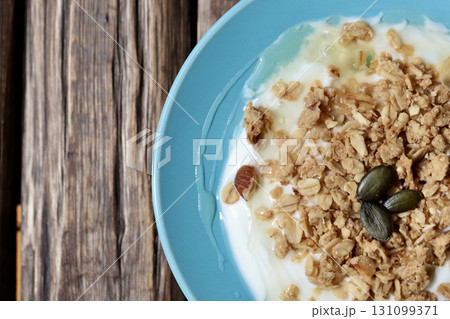平たいお皿に入れたハチミツをかけたグラノーラヨーグルト 平たいお皿に入れたハチミツをかけたグラノーラヨーグルト 131099371