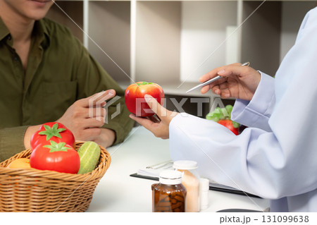 Healthy Eating Guidance. Doctor showing fresh produce to patient during nutrition consultation. Healthy Eating Guidance. Doctor showing fresh produce to patient during nutrition consultation. 131099638