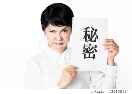 秘密と書かれた紙を持ち威嚇するシニア女性 秘密と書かれた紙を持ち威嚇するシニア女性 131100154