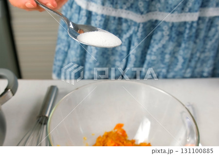 Woman hands cooking adding salt to bowl preparing vegetable sauce on kitchen. Woman hands cooking adding salt to bowl preparing vegetable sauce on kitchen. 131100885