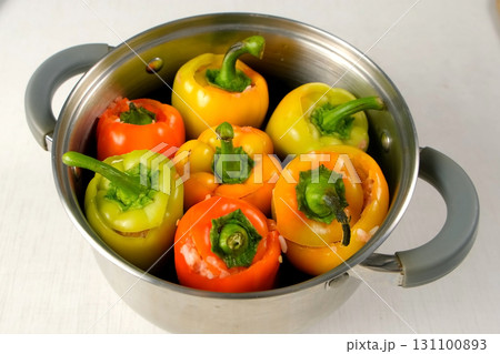 Colorful bell peppers filled minced meat rotating in cooking saucepan on kitchen 131100893