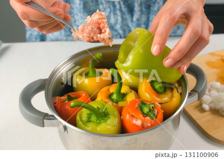 Woman hands are filling bell pepper with minced meat rice cooking on kitchen. Woman hands are filling bell pepper with minced meat rice cooking on kitchen. 131100906