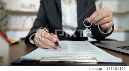 Lawyer holding house key and signing real estate contract 131101121