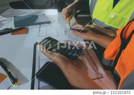 Closeup of team of industrial engineers meeting analyze machinery blueprints consult project on table in manufacturing factory. Working in manufacturing plant or production plant. Closeup of team of industrial engineers meeting analyze machinery blueprints consult project on table in manufacturing factory. Working in manufacturing plant or production plant. 131101872