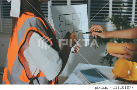 Closeup of team of industrial engineers meeting analyze machinery blueprints consult project on table in manufacturing factory. Working in manufacturing plant or production plant. 131101877