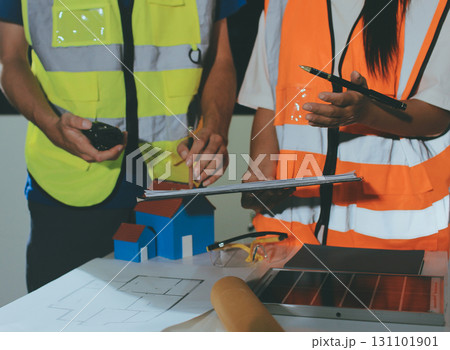 Closeup of team of industrial engineers meeting analyze machinery blueprints consult project on table in manufacturing factory. Working in manufacturing plant or production plant. Closeup of team of industrial engineers meeting analyze machinery blueprints consult project on table in manufacturing factory. Working in manufacturing plant or production plant. 131101901