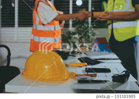 Closeup of team of industrial engineers meeting analyze machinery blueprints consult project on table in manufacturing factory. Working in manufacturing plant or production plant. Closeup of team of industrial engineers meeting analyze machinery blueprints consult project on table in manufacturing factory. Working in manufacturing plant or production plant. 131101905