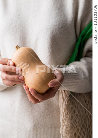 Butternut squash pumpkin holding by woman hand Butternut squash pumpkin holding by woman hand 131103736