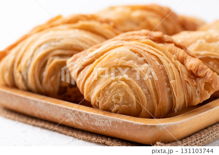 Curry puff stuffed with chicken or sweet potatoes on wooden plate, Thai snack food style 131103744