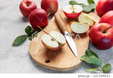 Fresh red apples and slices with knife on wooden cutting board 131104012