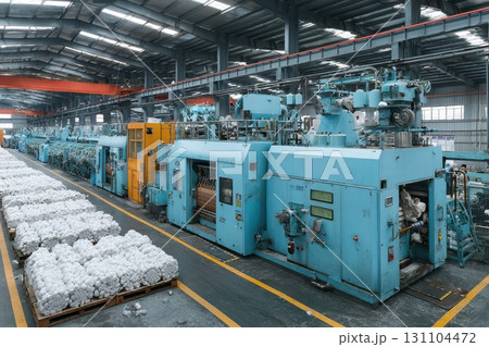 Inside a textile factory, large industrial machines process cotton bales, showcasing automated manufacturing and the large-scale production within the industry 131104472