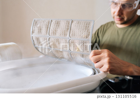 Close-up shot of technician wearing protective glasses sanitizing air humidifier using high-temperature steam cleaner, eliminating dust, dirt and harmful bacteria for cleaner indoor environment. Close-up shot of technician wearing protective glasses sanitizing air humidifier using high-temperature steam cleaner, eliminating dust, dirt and harmful bacteria for cleaner indoor environment. 131105516