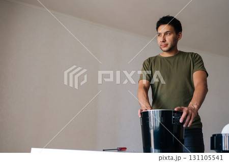 Portrait of professional technician fixing portable air humidifier, servicing electrical components for optimal home air quality and personal wellness. Concept of modern housekeeping appliance. 131105541
