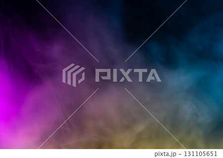 Colorful smoke or fog on dark background with gradient effect, abstract texture in purple, blue, yellow tones, concept of fantasy, atmosphere, and art design. 131105651