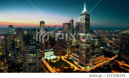 City skyline at dusk with illuminated skyscrapers and colorful sunset sky City skyline at dusk with illuminated skyscrapers and colorful sunset sky 131106291