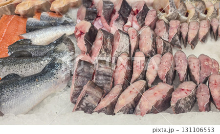 Frozen sea and freshwater fish on a supermarket shelf Sliced and whole Seafood 131106553