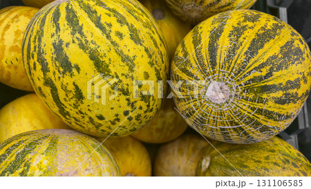 Round yellow melons in large crates on store shelves. Fruit display and sale. Round yellow melons in large crates on store shelves. Fruit display and sale. 131106585