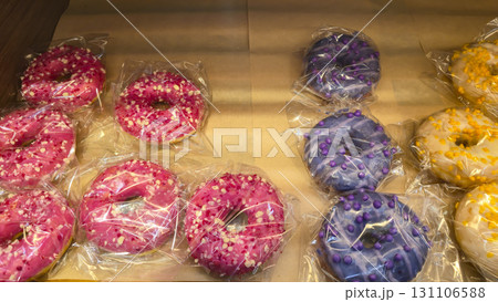Donuts in colorful glazes are displayed in the store. Freshly baked goods. 131106588