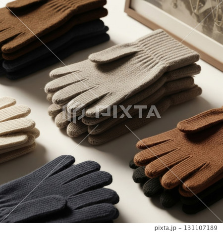 Arrangement of Assorted Wool Gloves on Creamy Surface with Warm Interior Lighting 131107189